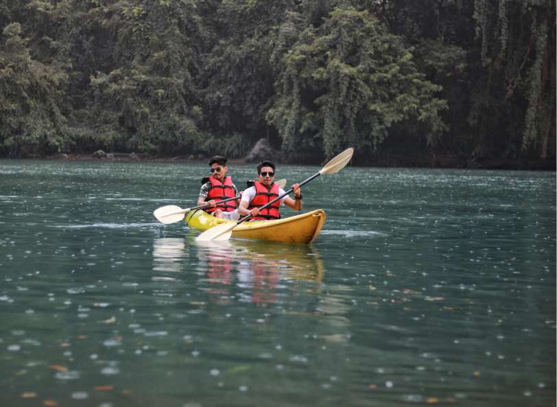 Two men on a yellow kayack paddling in a lake